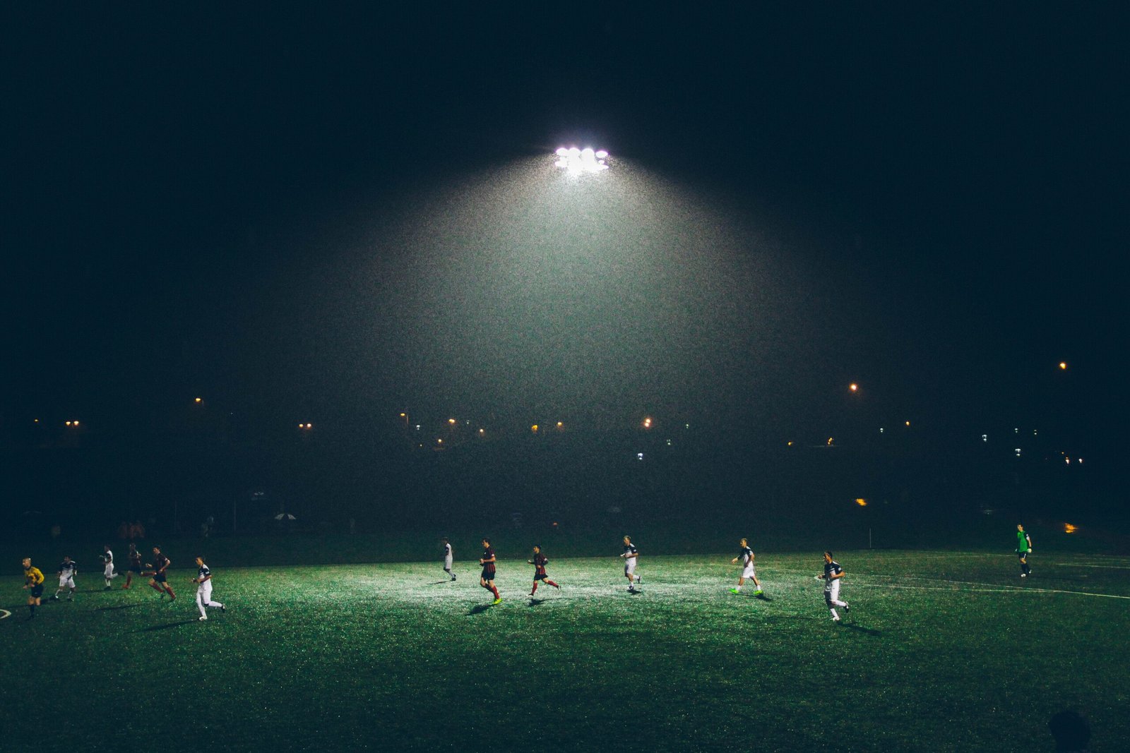 Youth soccer players on a floodlit field at night